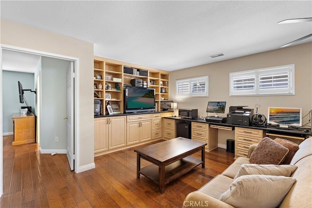 living area with baseboards, visible vents, and dark wood finished floors