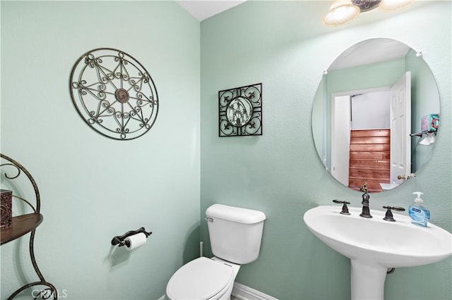 bathroom featuring a sink, toilet, and baseboards