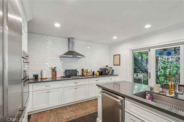 kitchen with stainless steel appliances, dark wood-type flooring, wall chimney range hood, backsplash, and dark countertops