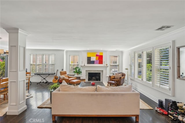 living room featuring ornate columns, visible vents, and a wealth of natural light