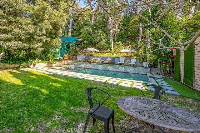 view of community with a swimming pool, a patio, and a yard