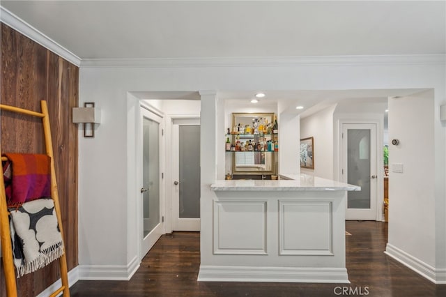 interior space featuring ornamental molding, a bar, and dark wood finished floors