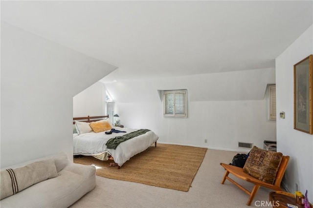 carpeted bedroom with lofted ceiling, baseboards, and visible vents