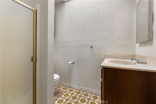 full bathroom featuring baseboards, toilet, a shower with door, tile patterned floors, and vanity