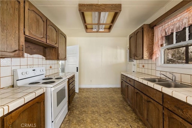 kitchen with tile countertops, a sink, white range with electric stovetop, and decorative backsplash