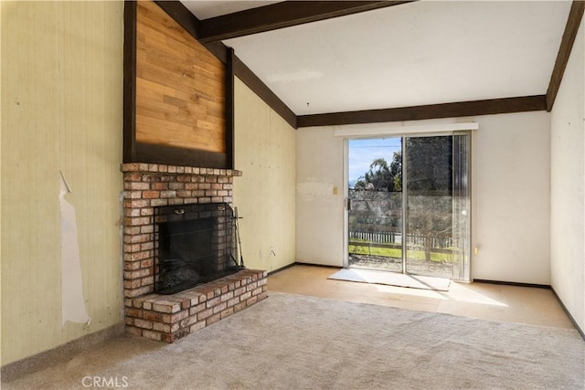 unfurnished living room with vaulted ceiling with beams, a brick fireplace, carpet flooring, and baseboards