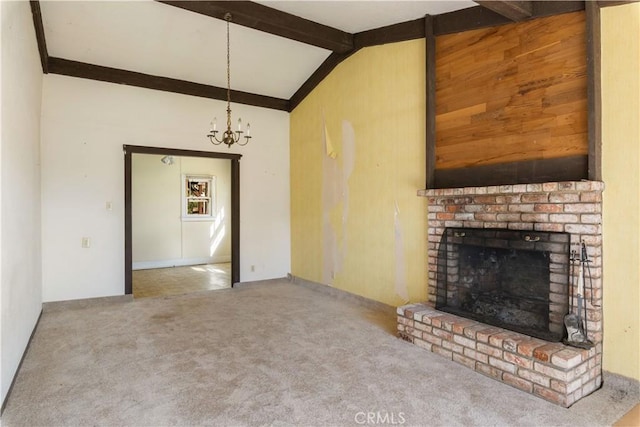 unfurnished living room with a brick fireplace, carpet flooring, vaulted ceiling with beams, and a notable chandelier