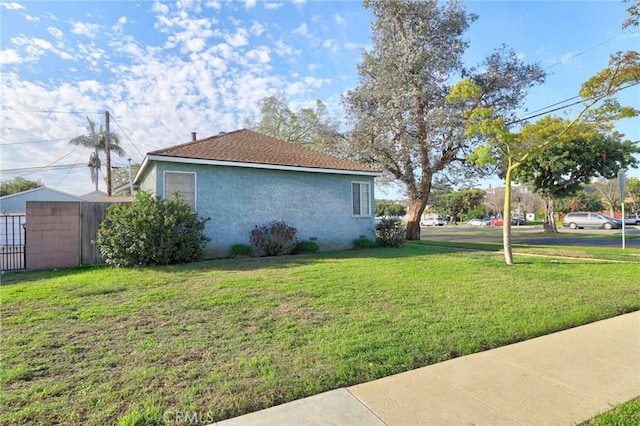 view of property exterior with a lawn and stucco siding