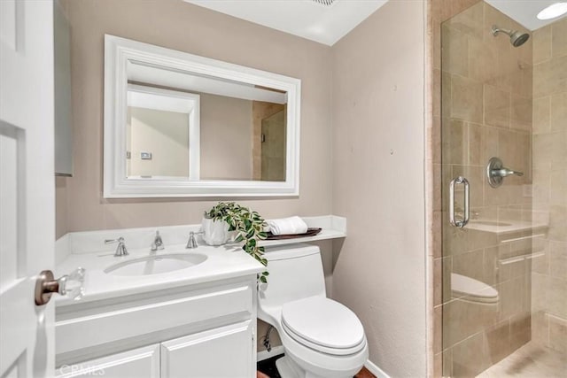 bathroom with a shower stall, toilet, and vanity