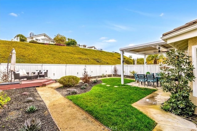 view of yard with a deck, a patio area, a fenced backyard, and an outdoor living space