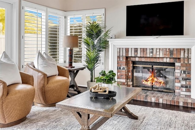 sitting room with a fireplace and wood finished floors