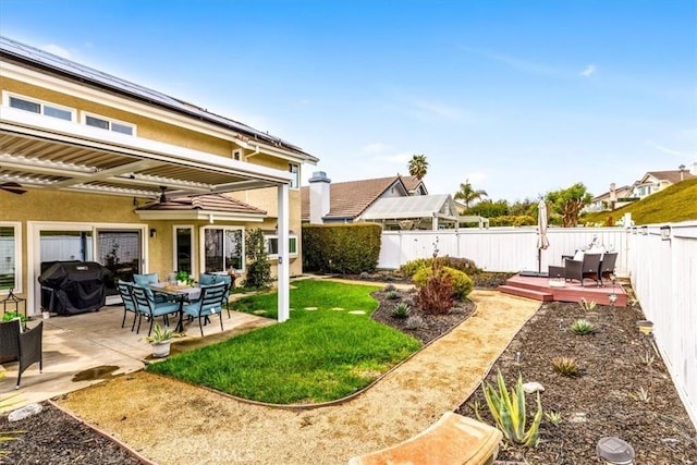 view of yard featuring a deck, a patio area, and a fenced backyard