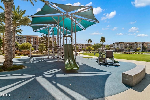 view of property's community featuring a residential view, a lawn, and playground community