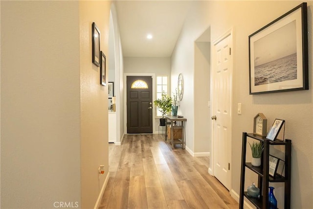 doorway to outside with baseboards and light wood-style floors