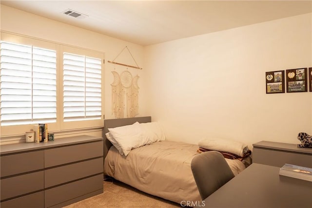 bedroom featuring visible vents and light carpet