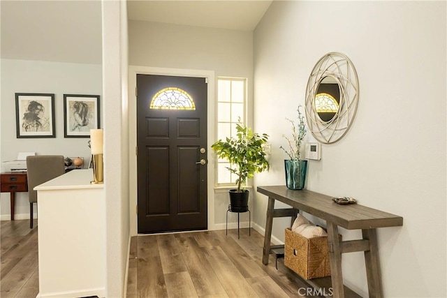 entryway featuring baseboards and wood finished floors