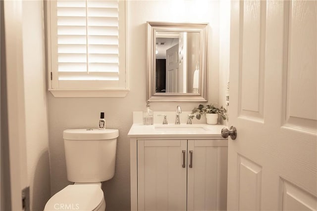 half bathroom with vanity and toilet