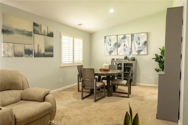 dining area with lofted ceiling, baseboards, visible vents, and light colored carpet