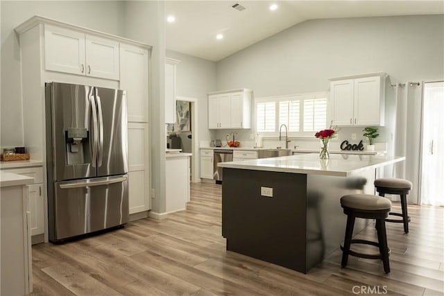 kitchen featuring a sink, white cabinetry, light countertops, appliances with stainless steel finishes, and light wood-type flooring