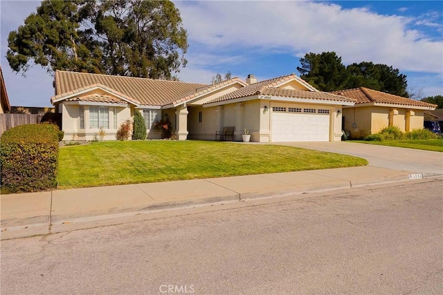 view of front of house with driveway, a tiled roof, an attached garage, a front lawn, and stucco siding