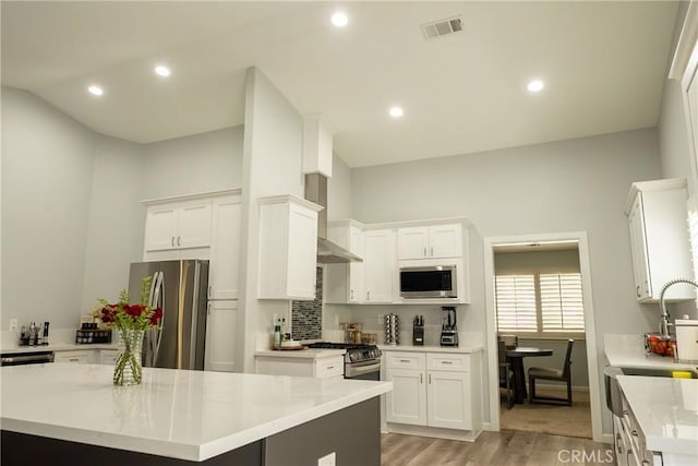 kitchen with visible vents, white cabinets, light wood-style flooring, appliances with stainless steel finishes, and light countertops