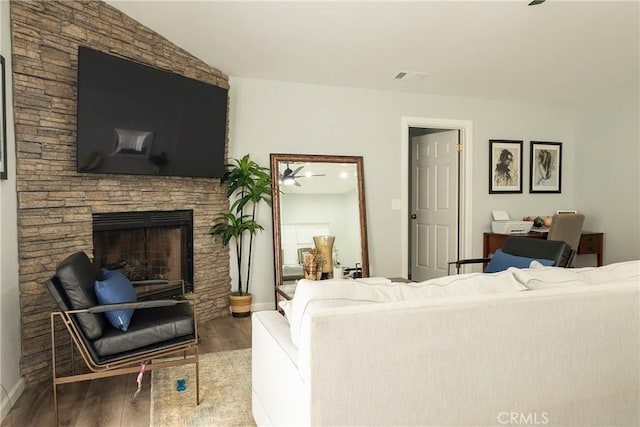 living area featuring visible vents, a fireplace, baseboards, and wood finished floors