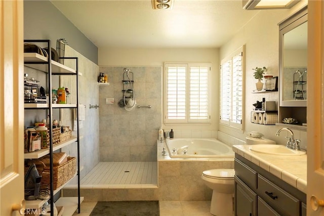 full bathroom featuring toilet, a tile shower, vanity, a tub with jets, and tile patterned floors