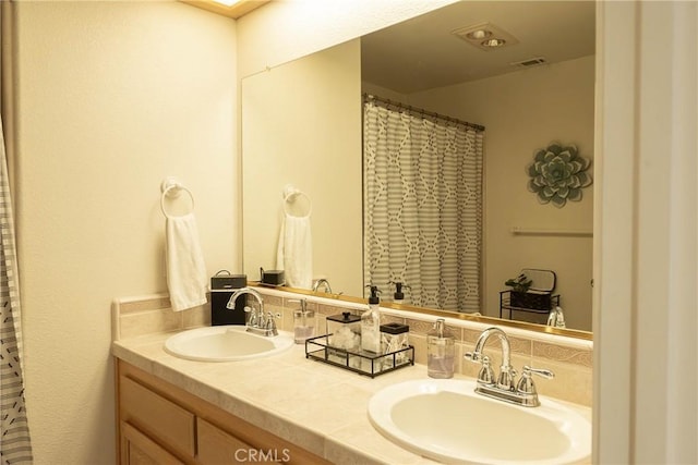 bathroom with double vanity, tasteful backsplash, visible vents, and a sink