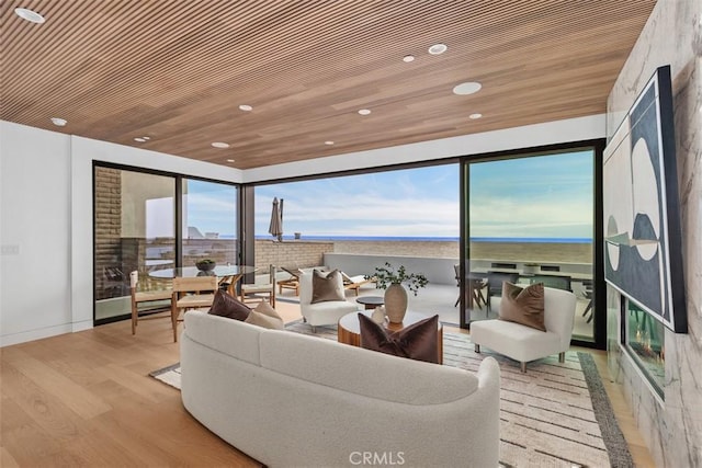 living room with a water view, wood finished floors, wood ceiling, and recessed lighting