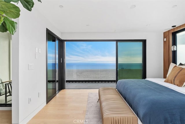 bedroom with access to outside, baseboards, and wood finished floors