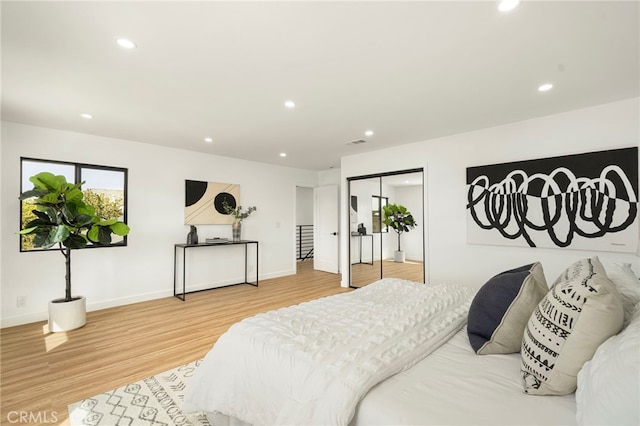 bedroom with recessed lighting, a closet, visible vents, wood finished floors, and baseboards