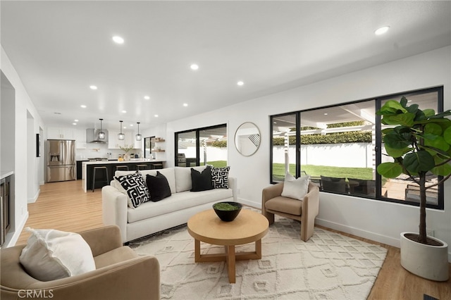 living room featuring light wood-style floors, baseboards, and recessed lighting