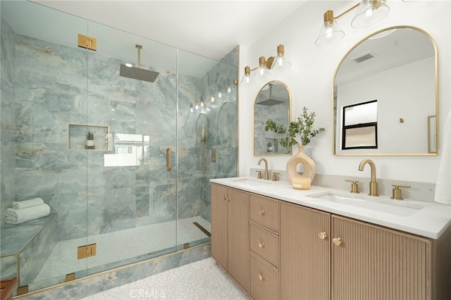 full bath featuring visible vents, a sink, a shower stall, and double vanity