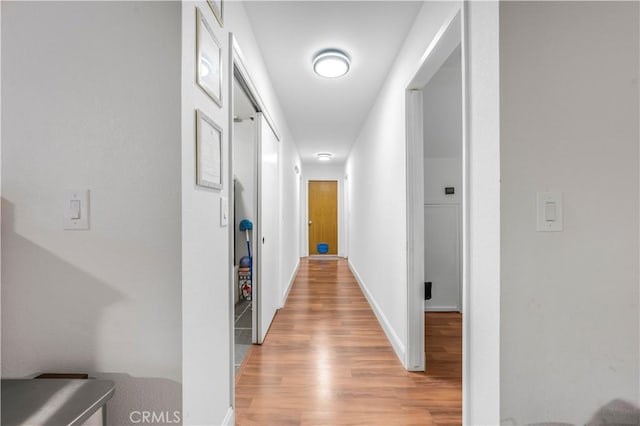 hallway with light wood-style floors and baseboards