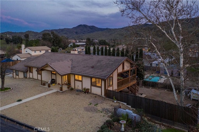 view of front facade with fence, a mountain view, a patio, and stucco siding