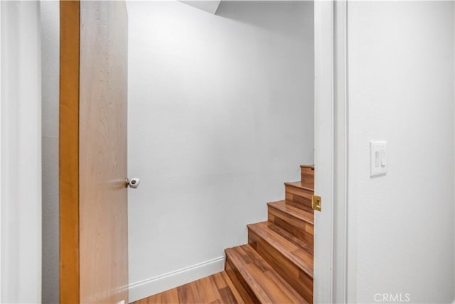 stairway featuring wood finished floors and baseboards