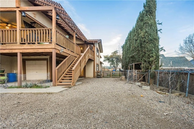 exterior space with stucco siding, stairs, fence, and a wooden deck