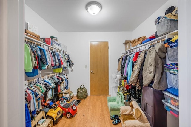 walk in closet with wood finished floors