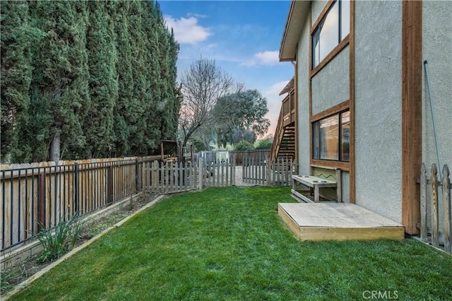 view of yard with a fenced backyard and stairs