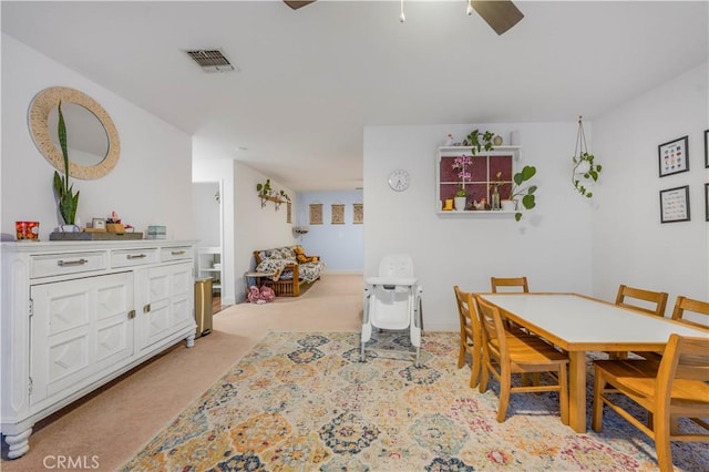 dining room with ceiling fan, visible vents, and light colored carpet