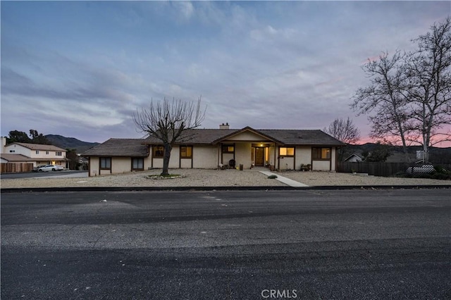 view of front facade featuring fence and stucco siding