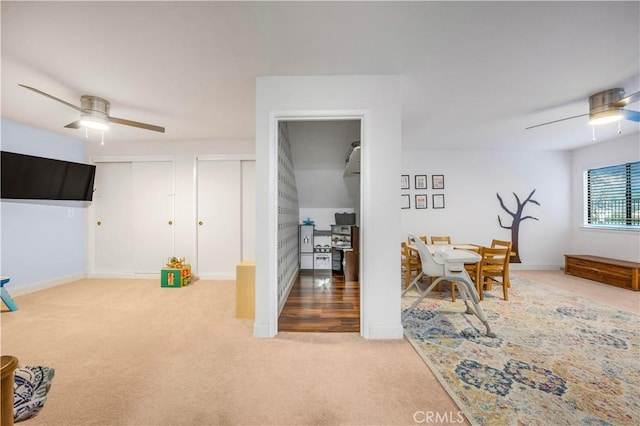 interior space with carpet floors, baseboards, and a ceiling fan