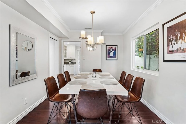 dining room with a chandelier, ornamental molding, baseboards, and dark wood-style flooring