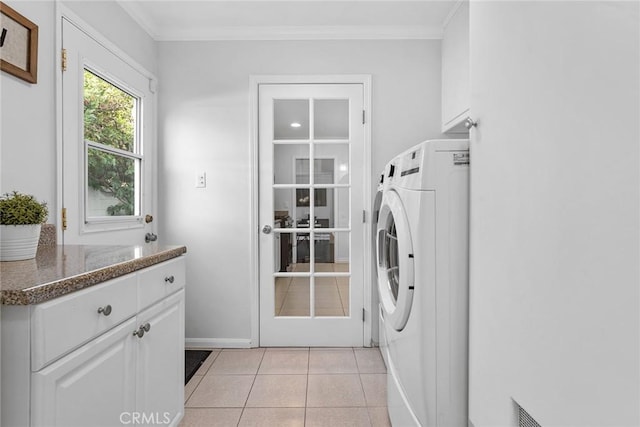 laundry area featuring crown molding, baseboards, light tile patterned floors, cabinet space, and washer / clothes dryer