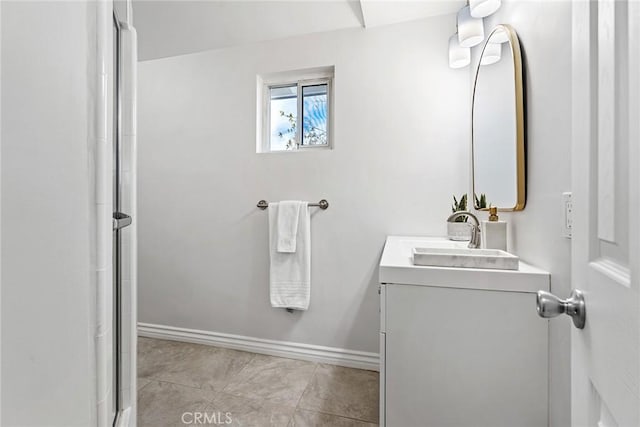 bathroom featuring a shower, baseboards, vanity, and tile patterned flooring