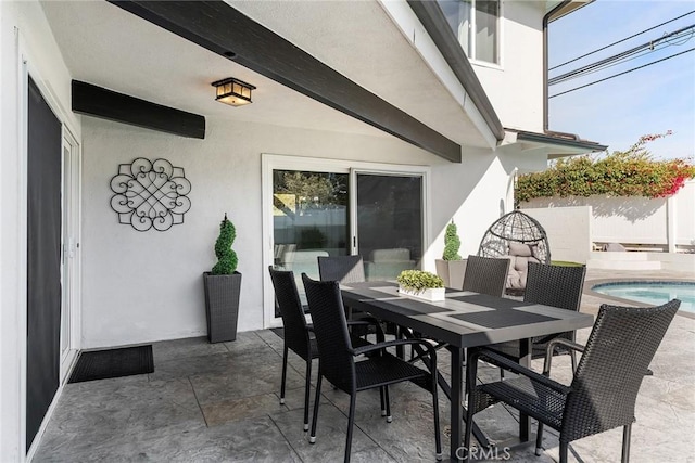 view of patio featuring an outdoor pool, outdoor dining space, and fence