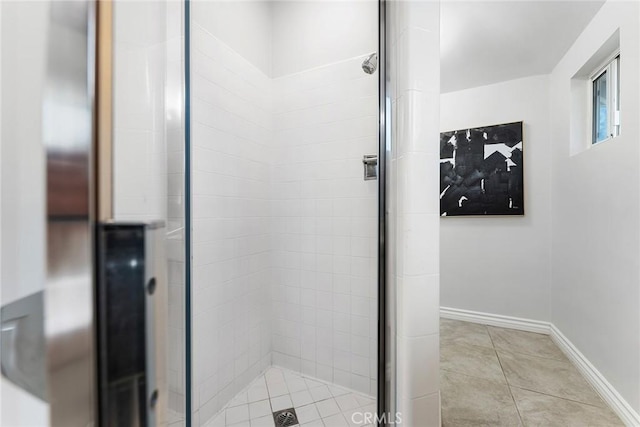 full bathroom featuring tile patterned flooring, a shower stall, and baseboards