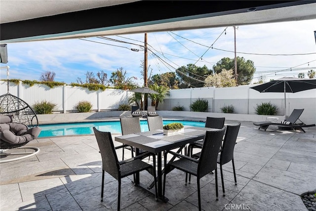 view of pool with outdoor dining space, a patio, a fenced backyard, and a fenced in pool
