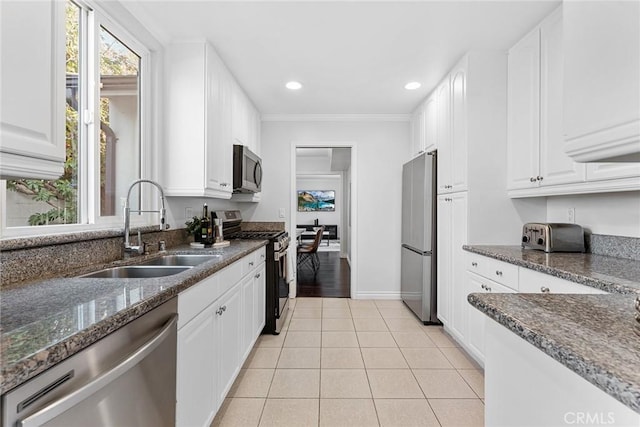 kitchen with light tile patterned floors, white cabinetry, stainless steel appliances, and a sink