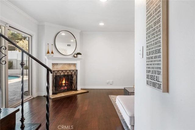 unfurnished living room featuring a warm lit fireplace, wood finished floors, and ornamental molding